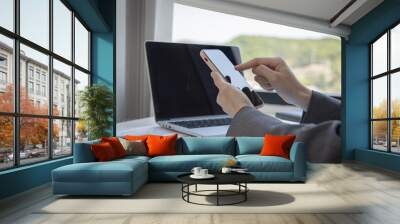 Finance workers are reviewing the company's financial data on a laptop and using smartphones to communicate or chat with the team at social distances, Working during the virus outbreak. Wall mural