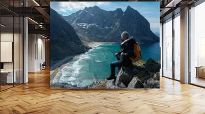 Man sitting on cliff edge alone enjoying aerial view backpacking lifestyle travel adventure outdoor vacations in Norway top of Reinebringen mountain. Wall mural