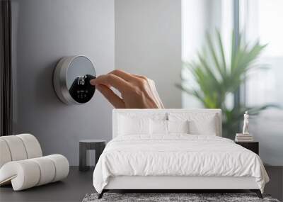 A person in casual attire adjusts the smart thermostat in a modern living room filled with natural light and stylish decor Wall mural