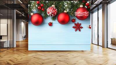 Beautiful Christmas decorations with red ornaments and snow on a blue wooden tabletop create a festive holiday atmosphere Wall mural