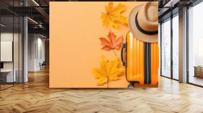 Bright Yellow Luggage Surrounded by Colorful Autumn Leaves on Orange Background Wall mural