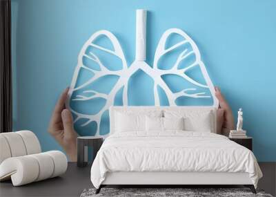 Hands presenting a lung silhouette illustration on a light blue backdrop for World No Smoking Day awareness Wall mural