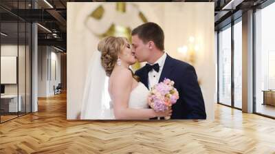 Beauty bride and handsome groom are registering the marriage. Wedding couple is marrying. Beautiful model girl in white dress and in lace veil. Man in suit. Female and male portrait. Cute lady and guy Wall mural