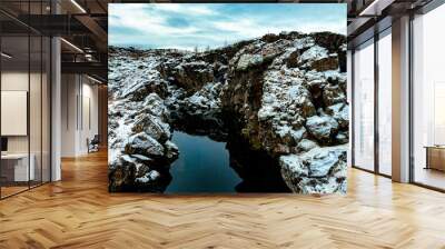 'Peninga' means 'coin' and 'gjá' means 'crack' or 'gorge'. So, 'Peningagjá' can be translated as 'Cracked Coin'. at thingvellir, Iceland. Wall mural