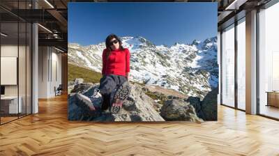 red cardigan woman sitting posing on peak mountains Wall mural