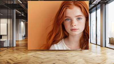 Closeup of natural beauty ginger Irish little girl isolated on orange background. Fashion, beauty, skincare, kid cosmetics concept. Commercial portrait for banner, poster with copy space Wall mural