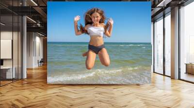 Flying jump beach little happy girl on blue sea shore in summer vacation Wall mural