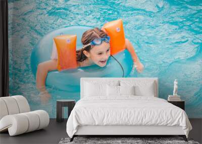 little girls is swimming in the pool by a summer day Wall mural