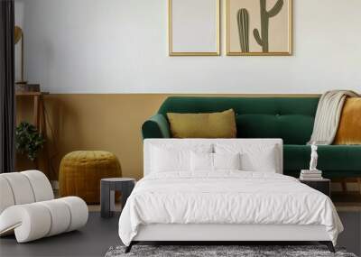 Stylish Scandinavian modern living room interior design, with three empty art frames mock up on the wall, green velvet sofa with cushions, ginger yellow stool, woolen carpet with plants.  Wall mural