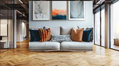 A cozy modern living room featuring a beige sofa adorned with colorful cushions and three abstract art pieces on the wall. Wall mural