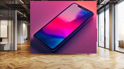 A smartphone with a colorful screen placed on a reflective surface with a pink to purple gradient background Wall mural