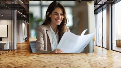 Confident businesswoman smiling while examining documents, conveying expertise and professionalism in an office setting Wall mural