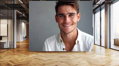 Smiling Young Man Wearing White Shirt in Studio Setting Wall mural