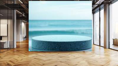 A serene seaside scene featuring a minimalist pedestal surrounded by turquoise stones, perfect for product displays or creative visuals. Wall mural