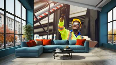 Black African American worker as staff foreman proud to happy smile working control loading cargo in shipping logistic warehouse with safety suit. Wall mural