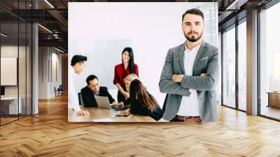 Business man executive hand some business owner with team work meeting in the office, male looking camera. Wall mural