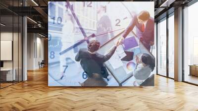 Business race against times deal project agreement concept. Businessman hand shaking overlay with time clock. Wall mural