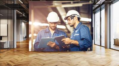 Engineer audit worker working team together with safety uniform and white helmet to work in industry factory handle tablet and checklist. Wall mural