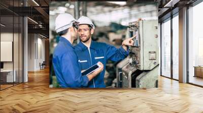 engineer teamwork checking control panel and teaching new worker to operating control the machine in factory. Wall mural