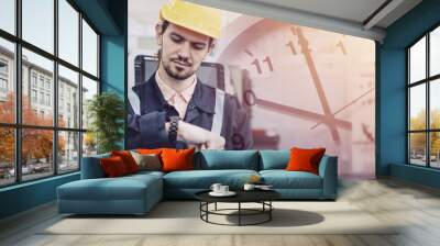 Engineer worker worry looking at wristwatch overlay time clock face. Industry factory late working hours concept. Wall mural