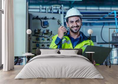 Portrait electricity worker hispanic engineer working in factory checking high voltage electrical power cabinet in factory. Wall mural