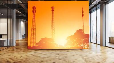 silhouette multiple band telephone cellsite towers antenna on sunset dusk orange sky Wall mural