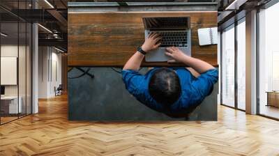 Young Asian businesswoman using laptop on wooden table Wall mural