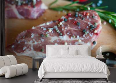 Raw pork meat sprinkled with pepper and salt with chopped tomato and rosemary steak cooking process Wall mural