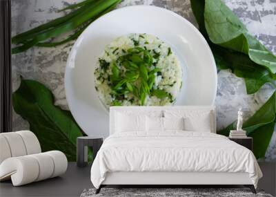 Vegan, vegetarian delicious dish. Rice with spinach on a white plate and fresh spinach leaves on the table, flatlay. Concept of healthy eating Wall mural