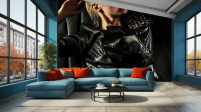 Young blonde woman in black leather jacket,leggings,shoes poses Wall mural