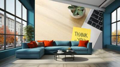 Top View Of Yellow Sticky Note Written Thank You on Laptop With Succulent Over Wooden Background Wall mural