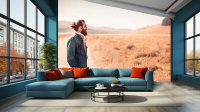 Attractive young man standing in the field Wall mural