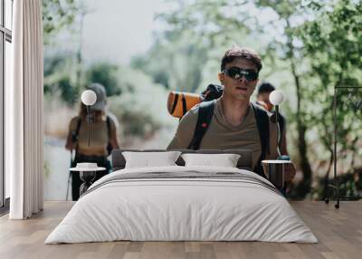 A group of friends hiking in a forest, carrying essential gear and enjoying the outdoor adventure together. Wall mural