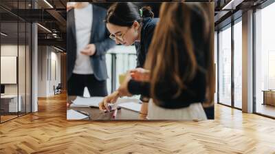 A group of students are working together on an academic project, receiving guidance and support from their professor. The image captures teamwork, collaboration, and a supportive learning environment. Wall mural