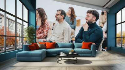 A multi generational, group of adult students with positive expressions engaged in a learning activity during a workshop, displaying attentiveness and interaction in a modern classroom setting. Wall mural