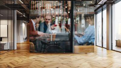 Business professionals having a casual meeting at an outdoor cafe, discussing work and collaborating on projects. Wall mural