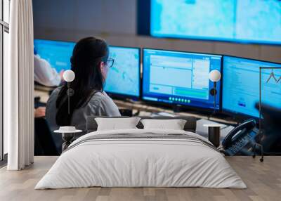 Female security guards working in surveillance room, monitoring cctv and discussing. Wall mural