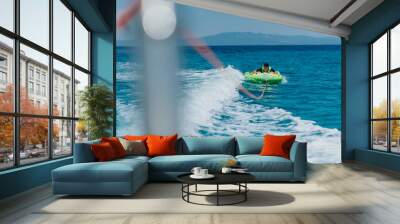 Summer speedboat tubing adventure on the sea with clear blue water and a green inflatable Wall mural