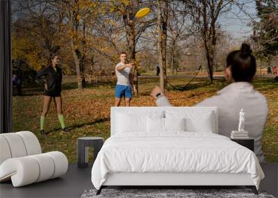 Three friends playing frisbee and enjoying Wall mural