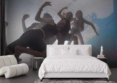 Young group of multiracial friends dancing enjoying and dancing together while improvising dance moves Wall mural