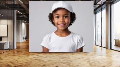 Little black girl with short hair wearing white t-shirt and white baseball cap isolated on grey background Wall mural