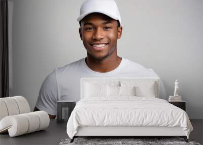 Young black man wearing white t-shirt and white baseball cap isolated on grey background Wall mural