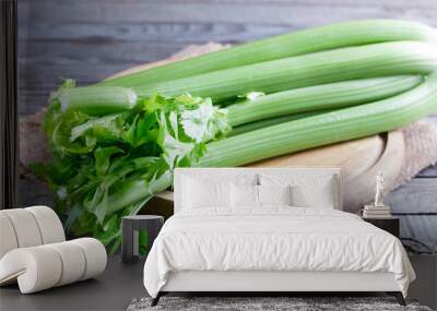 Fresh green celery stems on wooden cutting board Wall mural