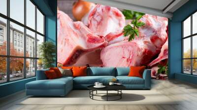 Raw beef bone for making broth on wooden background with vegetables and herbs. Banner Wall mural