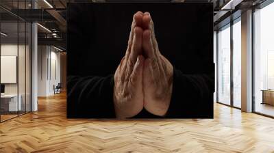 Close-up of hands woman in black clothes meditating, focus on arms in Namaste gesture Wall mural