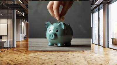 Child's hand placing coin in money box, concept of learning about saving. Wall mural