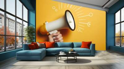 megaphone in hand on a empty yellow background, panoramic image with copy space. Wall mural