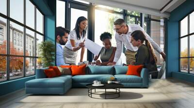 Exchanging ideas in the boardroom. Shot of a group of businesspeople having a meeting in a boardroom. Wall mural