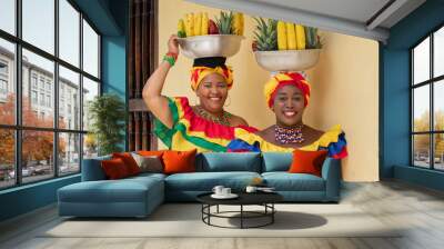 Cheerful fresh fruit street vendors aka Palenqueras in the Old Town of Cartagena de Indias, Colombia. Happy Afro-Colombian women in traditional clothing, Colombian culture and lifestyle.	 Wall mural