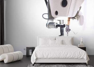 close up on working area of a modern industrial sewing machine equipped with a compensating sewing foot for highspeed seaming of fabric border in bright white light Wall mural